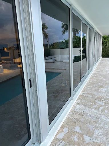 Large commercial-scale glass sliding door wall overlooking a pool